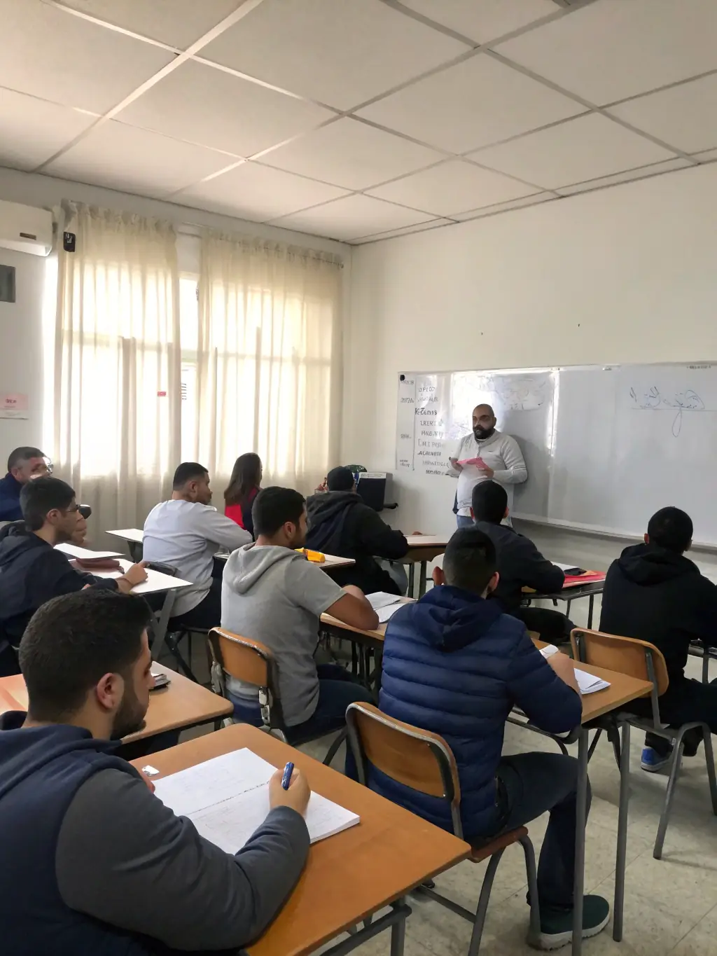 A classroom setting with an instructor explaining solar PV system design principles to a group of attentive students.